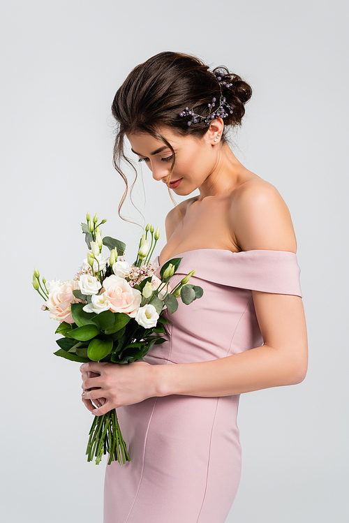 sensual bride in dress holding wedding bouquet isolated on grey
