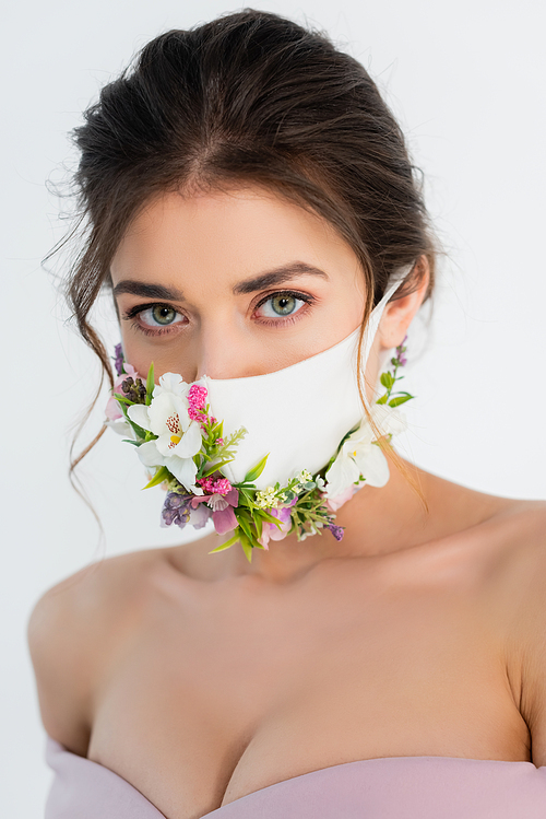 brunette woman in medical mask with flowers  isolated on grey