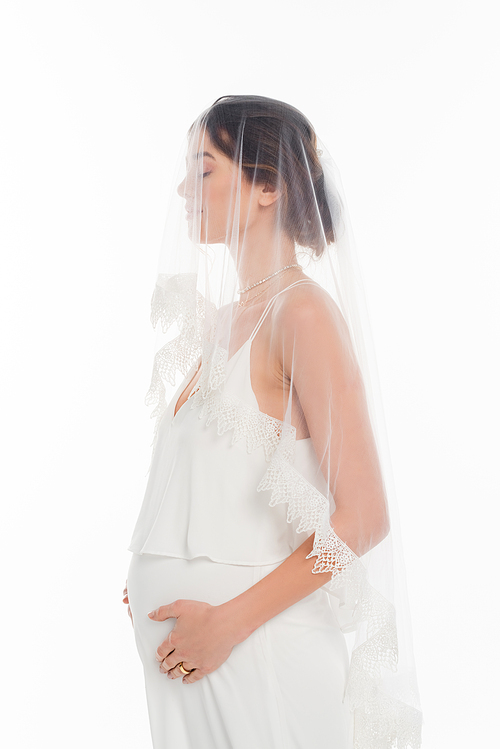pregnant woman in wedding dress and veil standing with closed eyes isolated on white