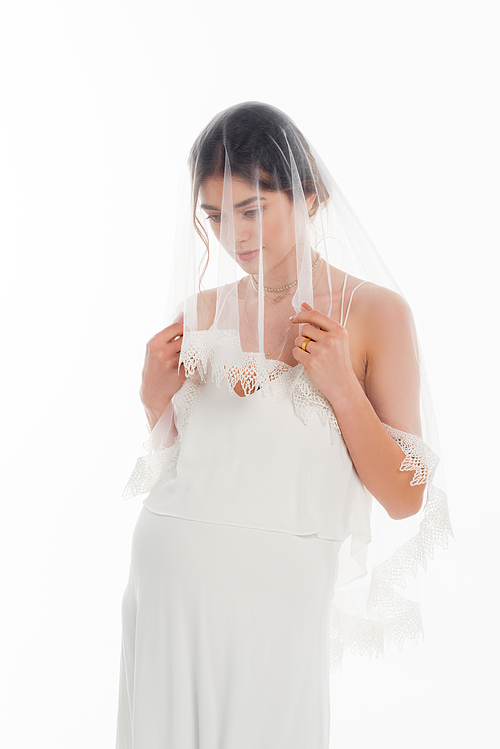 young pregnant woman in wedding dress and veil posing isolated on white
