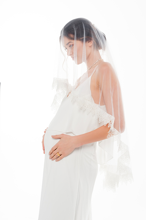 pregnant fiancee in veil touching tummy isolated on white