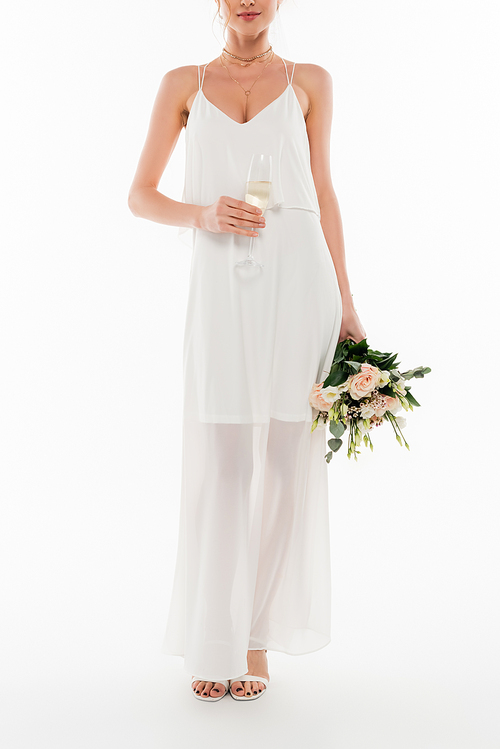 cropped view of young fiancee holding champagne glass and wedding bouquet on white