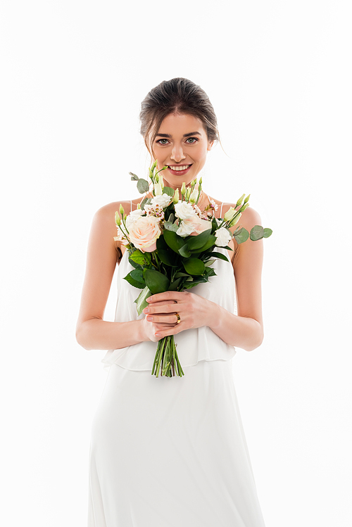 cheerful woman in wedding dress holding bouquet isolated on white