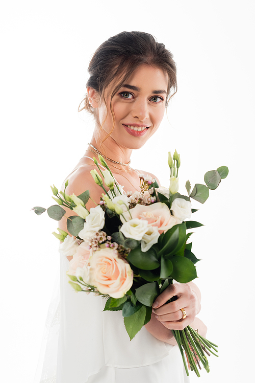 pretty fiancee smiling at camera while holding wedding bouquet isolated on white