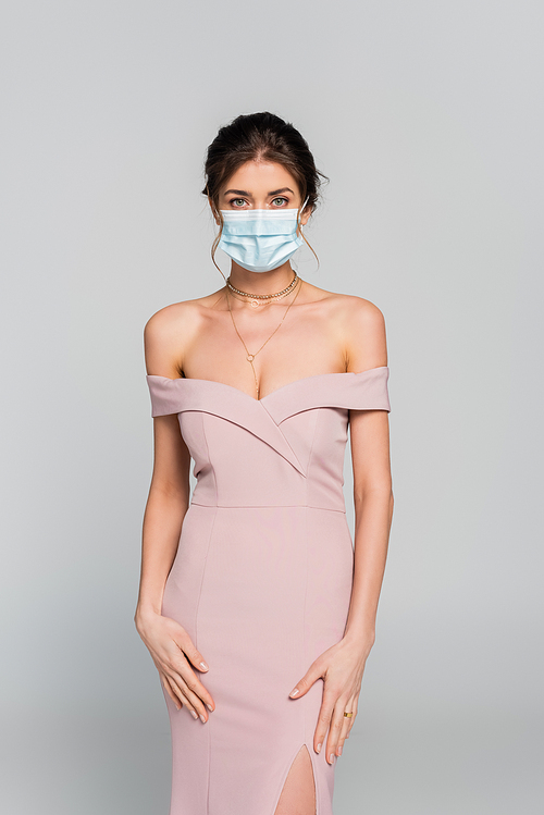 elegant woman in pink dress and medical mask  isolated on grey