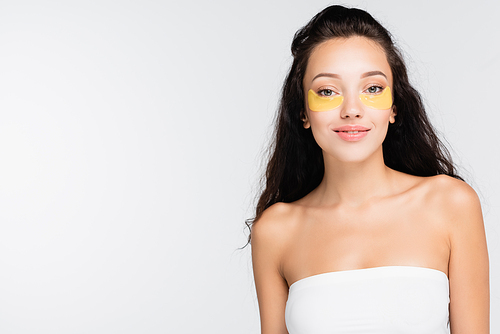 brunette woman with eye patches smiling and  isolated on white