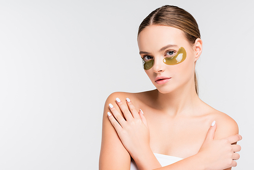 young woman with bare shoulders and eye patches isolated on white