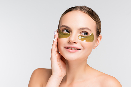 young woman with bare shoulders touching eye patch isolated on white