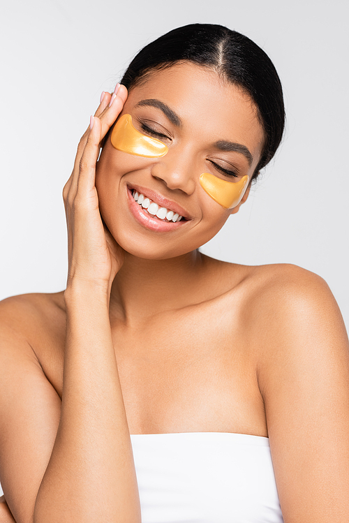 brunette african american woman in eye patches smiling isolated on white