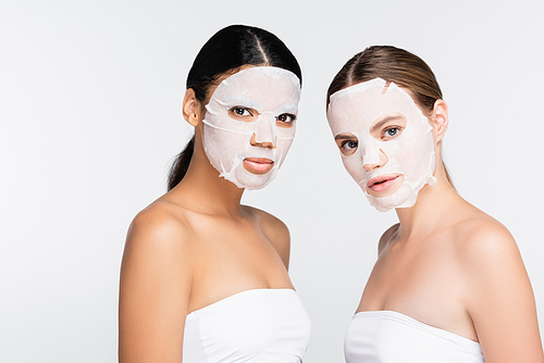 interracial women in sheet masks isolated on white