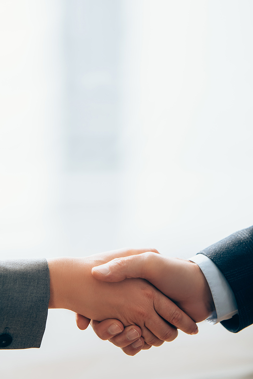 Cropped view of business partners shaking hands in office