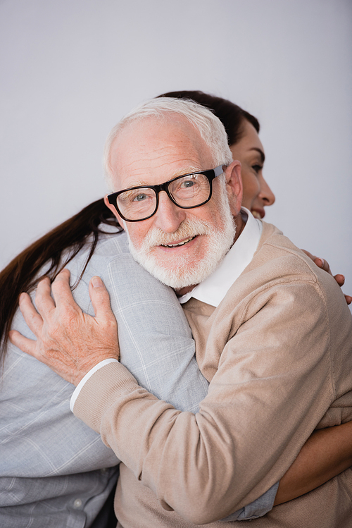 smiling aged man  while hugging adult daughter at home