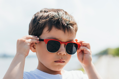 cute and serious boy wearing stylish sunglasses