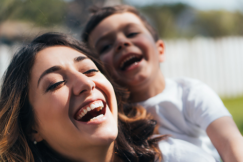 selective focus of happy mother laughing with cute son