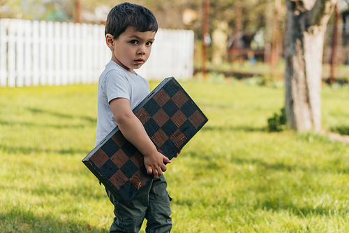 cute kid holding chessboard and 