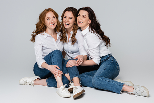 Positive women laughing on grey background