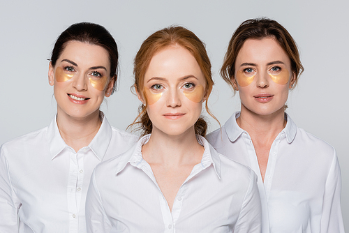 Adult women with eye patches smiling at camera isolated on grey