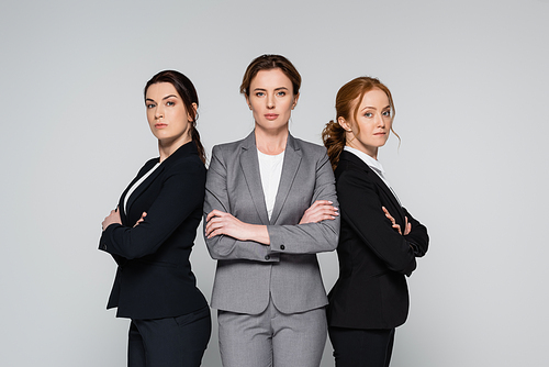 Businesswomen with crossed arms  isolated on grey