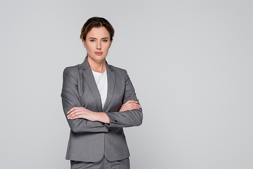 Confident businesswoman with crossed arms  isolated on grey