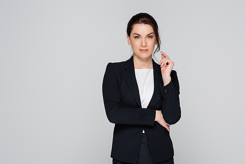 Successful businesswoman in black suit  isolated on grey