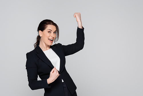 Cheerful businesswoman showing yes gesture isolated on grey