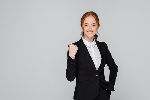 Red haired businesswoman showing yes gesture isolated on grey