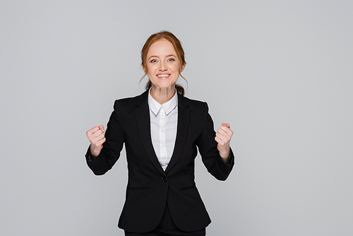 Red haired businesswoman showing yes gesture isolated on grey