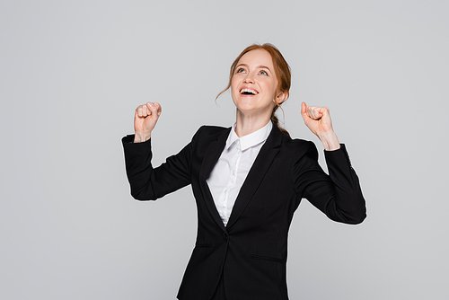 Excited manager showing yes gesture and looking up isolated on grey