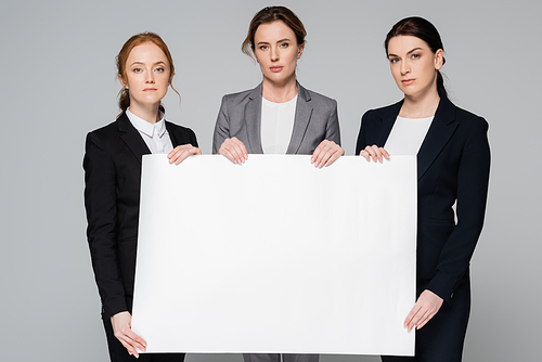 Businesswomen holding blank placard and  isolated on grey