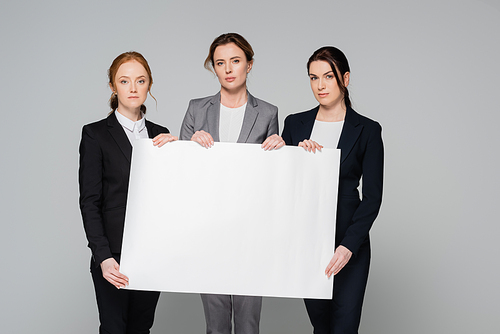 Businesswomen with white placard  isolated on grey