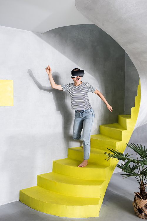Woman in virtual reality headset going down stairs
