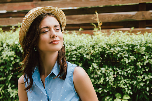 happy young woman with closed eyes in straw hat