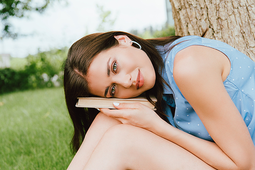 beautiful woman  while holding book outside