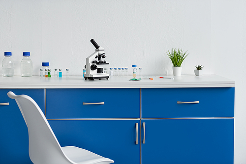 Microscope and vaccines on table in laboratory