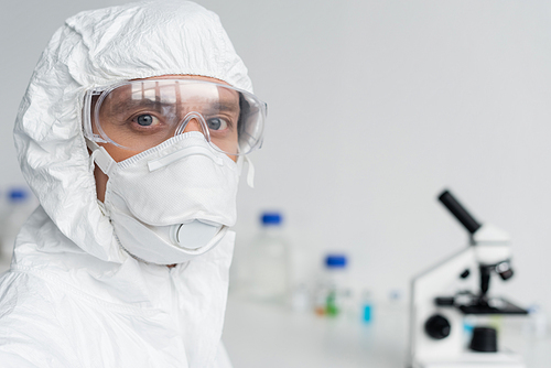 Scientist in goggles and hazmat suit  in laboratory