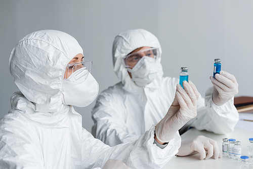 Scientist holding vaccine near colleague in laboratory