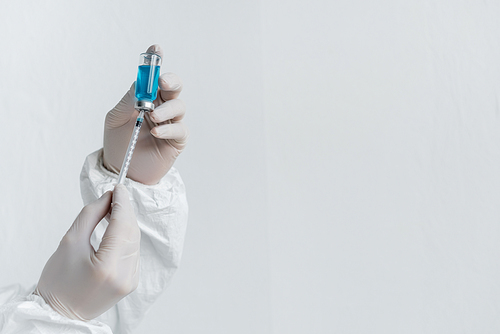 Cropped view of scientist in latex gloves holding vaccine and syringe