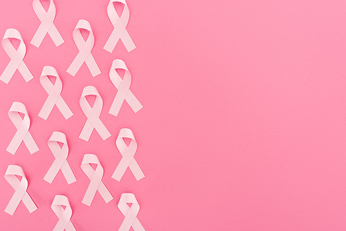 top view of pink breast cancer signs on pink background with copy space