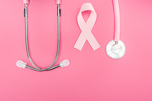 flat lay with stethoscope and pink breast cancer sign on pink background with copy space