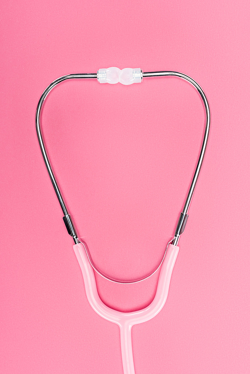 top view of medical stethoscope on pink background, breast cancer concept
