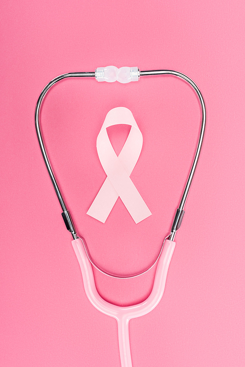 top view of pink breast cancer sign in stethoscope on pink background