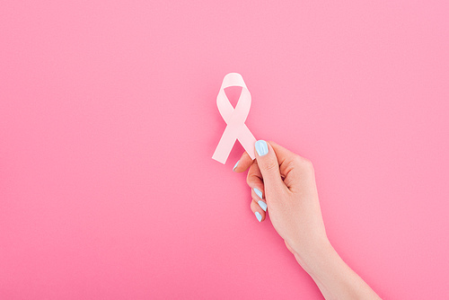 partial view of woman with pink breast cancer sign on pink background
