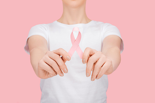 partial view of woman in white t-shirt holding pink breast cancer sign isolated on pink