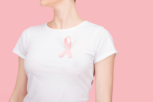 cropped view of woman with pink breast cancer sign isolated on pink