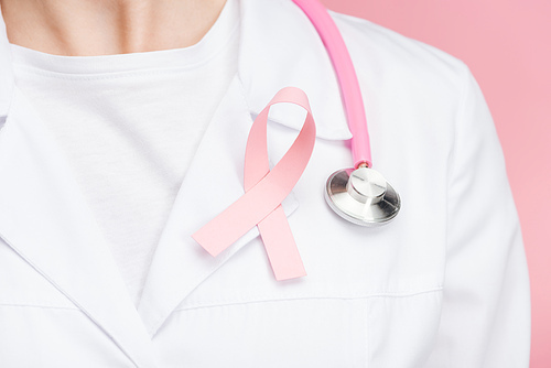 close up view of doctor in white coat with pink breast cancer sign and stethoscope isolated on pink