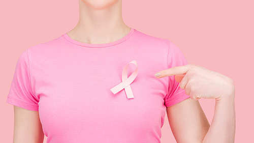 cropped view of woman in pink t-shirt pointing with finger at silk breast cancer sing isolated on pink