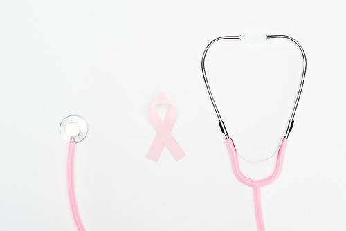 top view of stethoscope and pink breast cancer sign on pink background