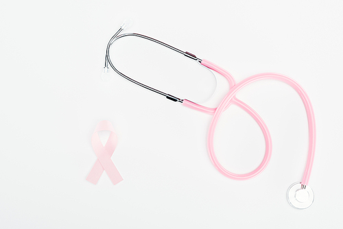 top view of stethoscope and pink breast cancer ribbon on white background