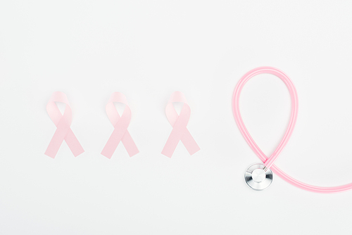 flat lay with stethoscope and pink breast cancer signs on white background
