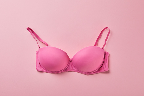 top view of brassiere on pink background, breast cancer concept